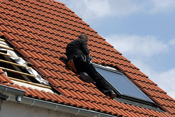 Couvreur au travail sur une toiture à Neuilly‑Plaisance